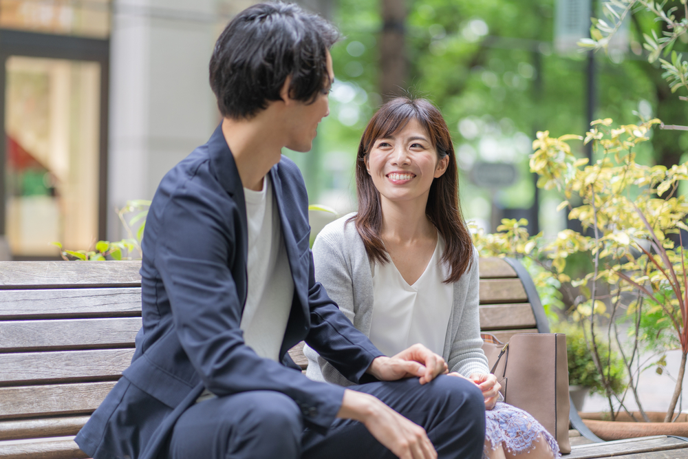 dating couple in 30s sitting on bench